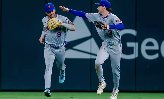 New York Mets center fielder A.J. Ewing (9) is congratulated by right fielder Carson Benge (3) after Ewing caught a sharp fly ball from Atlanta Braves' Ronald Acuña Jr. to end the eighth inning of a baseball game, Monday, Aug. 10, 2026, in Atlanta. (AP Photo/Erik S. Lesser)