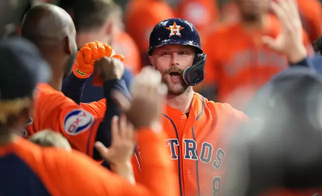 Houston Astros' Christian Walker celebrates in the dugout after hitting a home run against the Texas Rangers during the fifth inning of a baseball game Friday, July 31, 2026, in Houston. (AP Photo/David J. Phillip)