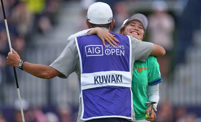 Shiho Kuwaki, of Japan, celebrates with her caddie after winning the Women's British Open golf championship in Lytham St Annes, England, Sunday, Aug. 2, 2026. (AP Photo/Jon Super)