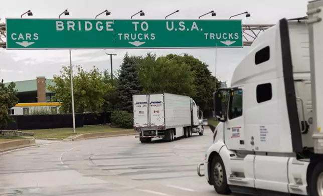 Transport trucks cross the Ambassador Bridge into the United States of America, in Windsor, Ontario, Canada, Saturday, Aug. 22, 2026. (Dax Melmer/The Canadian Press via AP)