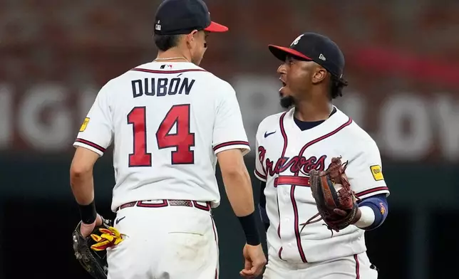 Atlanta Braves' Mauricio Dubón (14) and Ozzie Albies (1) celebrate a win over the New York Mets after a baseball game, Wednesday, Aug. 12, 2026, in Atlanta. (AP Photo/Mike Stewart)