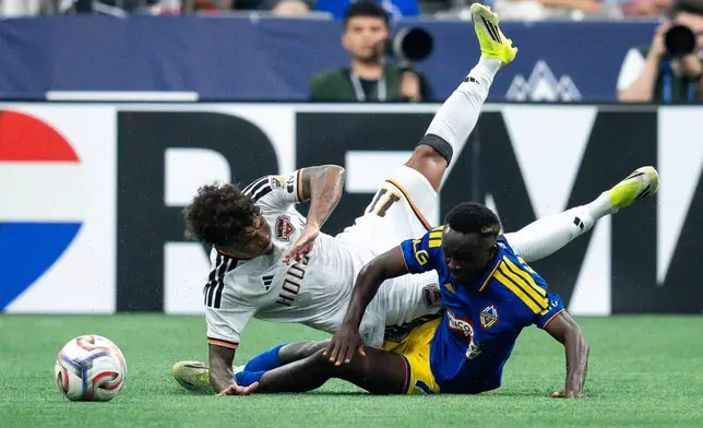 Houston Dynamo FC's Lawrence Ennali (11) and Vancouver Whitecaps' Cheick Sabaly (7) collide as they fight for the ball during the first half of an MLS soccer match in Vancouver, B.C., on Wednesday, Aug. 19, 2026. (Ethan Cairns/The Canadian Press via AP)
