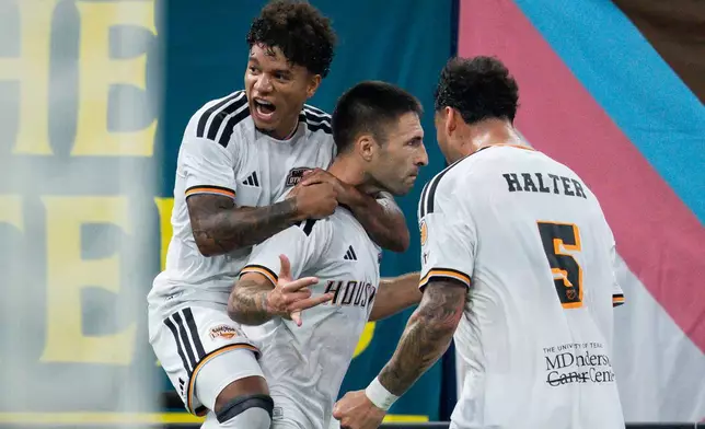 Houston Dynamo FC's Franco Negri, center, celebrates his goal against the Vancouver Whitecaps with Lawrence Ennali, left, and Lucas Halter during the first half of an MLS soccer match in Vancouver, B.C., on Wednesday, Aug. 19, 2026. (Ethan Cairns/The Canadian Press via AP)