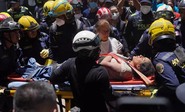 Rescue workers carry Diana Troncoso after pulling her from the rubble the day after an earthquake struck Cali, Colombia, Tuesday, Aug. 11, 2026. (AP Photo/Ivan Valencia) CORRECTION: Changes city to Cali, not Pereira.