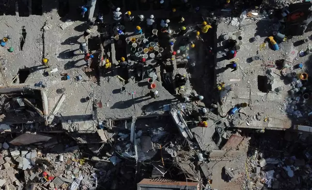 Volunteers and rescue workers use buckets to remove debris of a collapsed building a day after an earthquake struck Cali, Colombia, Tuesday, Aug. 11, 2026. (AP Photo/Santiago Saldarriaga)