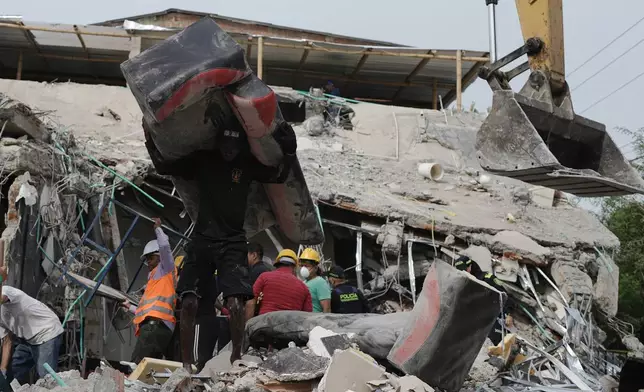 A man removes a sofa from a damaged house two days after an earthquake struck Cali, Colombia, Wednesday, Aug. 12, 2026. (AP Photo/Ivan Valencia)