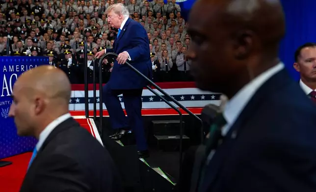 U.S. Secret Service agents stand watch as President Donald Trump walks on stage at the David Mack Center for Training and Intelligence, Friday, Aug. 14, 2026, in Garden City, N.Y. (AP Photo/Julia Demaree Nikhinson)