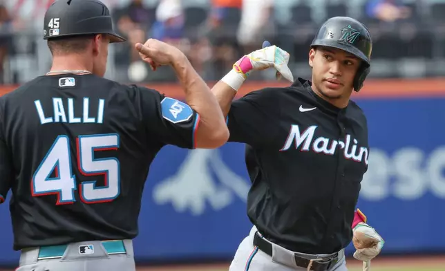 Miami Marlins' Javier Sanoja, right, gestures with third base coach Blake Lalli (45) after hitting a home run during the second inning of a baseball game against the New York Mets, Saturday, Aug. 1, 2026, in New York. (AP Photo/Heather Khalifa)