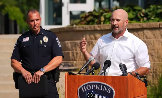 Hopkins Mayor Patrick Hanlon, flanked by Police Chief Brent Johnson, speaks at a news conference in Hopkins, Minn., Wednesday, Aug. 12, 2026, where police said a man who killed his wife and their 7-year-old daughter at an in-home daycare is also suspected of killing a 78-year-old female relative. (AP Photo/Ellen Schmidt)