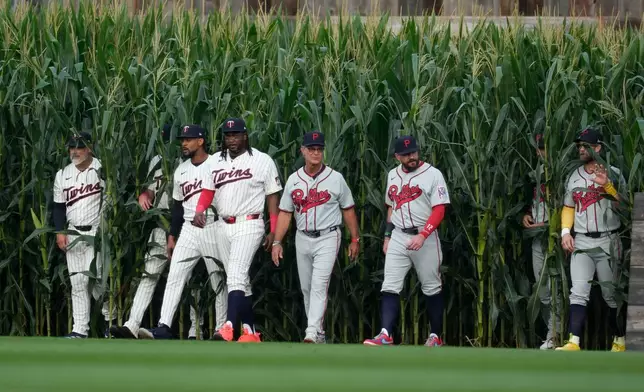 Players walk onto the field before a baseball game between the Minnesota Twins and the Philadelphia Phillies at the Field of Dreams movie site, Thursday, Aug. 13, 2026, in Dyersville, Iowa. (AP Photo/Charlie Neibergall)