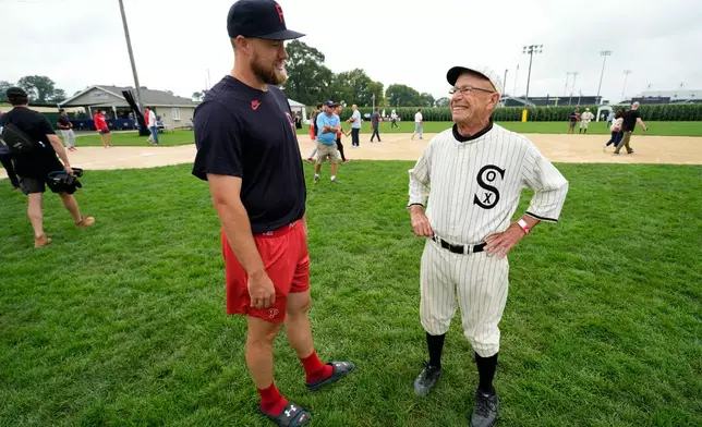 Philadelphia Phillies pitcher Jonathan Bowlan talks with Paul Scherrman, right, of Farley, Iowa, before a baseball game against the Minnesota Twins at the Field of Dreams movie site, Thursday, Aug. 13, 2026, in Dyersville, Iowa. (AP Photo/Charlie Neibergall)