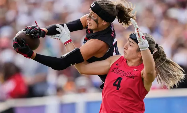 Isabella Geraci of the United States and Rosalie Landry of Canada challenge for the ball during the Flag Football World Championship women's final game between Canada and USA in Duesseldorf, Germany, Sunday, Aug. 16, 2026. (AP Photo/Martin Meissner)