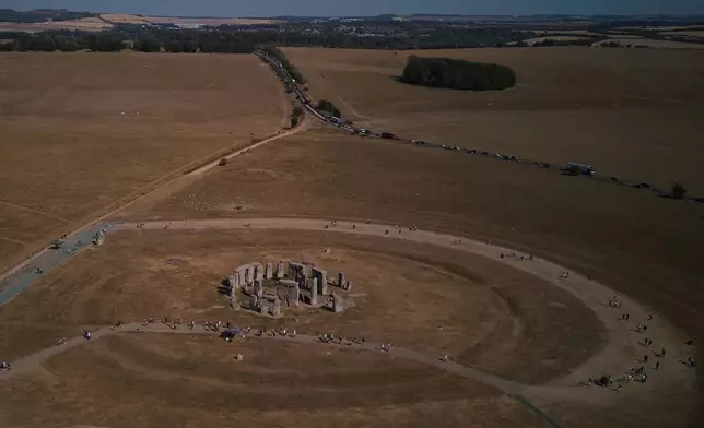 A general view of the ancient stone circle Stonehenge amid dried grass in Wiltshire, England, Thursday, Aug. 13, 2026. (AP Photo/Kin Cheung)