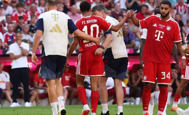 Munich's Jamal Musiala, center, leaves the pitch due to an injury during a pre-season soccer match between FC Bayern Munich and RB Leipzig in Munich, Germany, Saturday, Aug. 15, 2026. (Karl-Josef Hildenbrand/dpa via AP)
