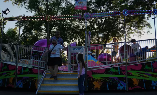 Dizzy riders tread lightly as they step off the Tilt-A-Whirl, Thursday, Aug. 27, 2026, at the Minnesota State Fair in Falcon Heights, Minn. (AP Photo/Ellen Schmidt)