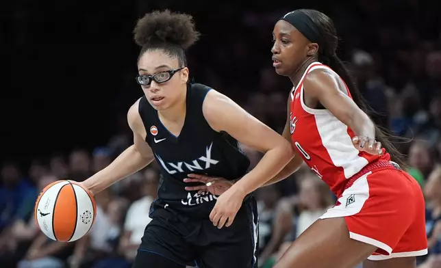 Minnesota Lynx guard Olivia Miles, left, works toward the basket as Las Vegas Aces guard Jackie Young defends during the first half of a WNBA basketball game in Minneapolis, Saturday, Aug. 8, 2026. (AP Photo/Abbie Parr)