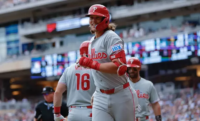 Philadelphia Phillies' Alec Bohm, center, celebrates after hitting a three-run home run during the sixth inning of a baseball game against the Minnesota Twins, Sunday, Aug. 16, 2026, in Minneapolis. (AP Photo/Bailey Hillesheim)