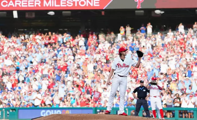 Philadelphia Phillies pitcher Aaron Nola receives a new ball after recording his 2,000th career strikeout during the second inning of a baseball game against the Toronto Blue Jays, Saturday, Aug. 8, 2026, in Philadelphia. (AP Photo/Derik Hamilton)