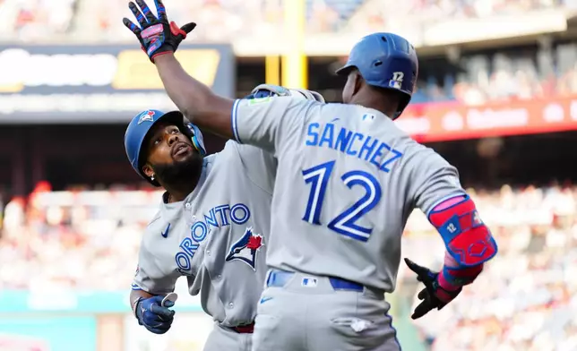Toronto Blue Jays' Vladimir Guerrero Jr., left, celebrates with Jesús Sánchez (12) after hitting a solo home run off Philadelphia Phillies pitcher Aaron Nola during the first inning of a baseball game, Saturday, Aug. 8, 2026, in Philadelphia. (AP Photo/Derik Hamilton)