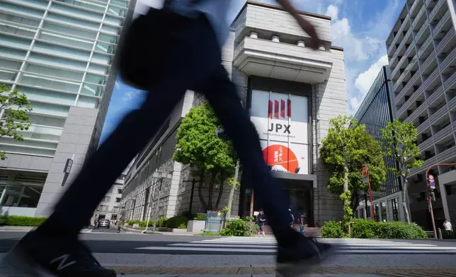 A person walk in front of Tokyo Stock Exchange Tuesday, Aug. 18, 2026, in Tokyo. (AP Photo/Eugene Hoshiko)