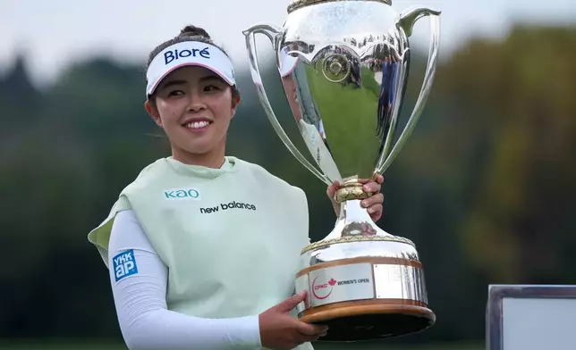 Miyu Yamashita, of Japan, celebrates with the trophy after winning the LPGA Canadian Women's Open golf tournament in Edmonton, Alberta, Sunday, Aug. 23, 2026. (Darryl Dyck/The Canadian Press via AP)