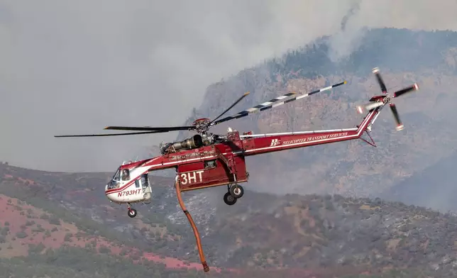 A Sikorsky Skycrane rises after refilling during efforts to fight the Widemouth 2 Fire east of Fillmore, Utah, on Tuesday, Aug. 4, 2026, before it crashed on Friday, Aug. 7. (Scott G Winterton/The Deseret News via AP)