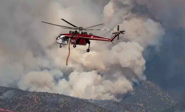 A Sikorsky Skycrane maneuvers into position to refill during efforts to fight the Widemouth 2 Fire east of Fillmore, Utah, on Tuesday, Aug. 4, 2026, before it crashed on Friday, Aug. 7. (Scott G Winterton/The Deseret News via AP)