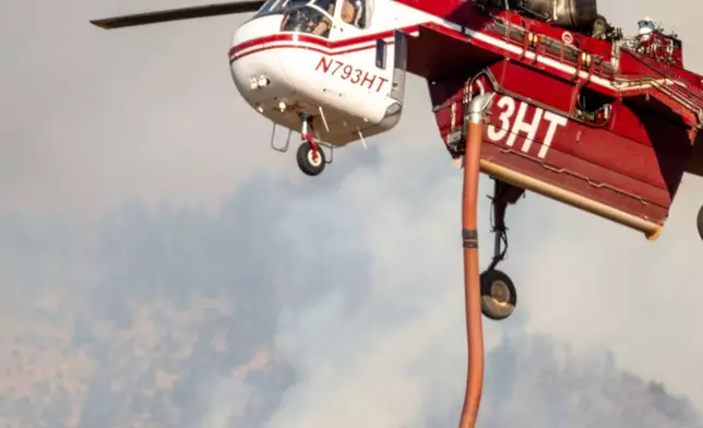 A Sikorsky Skycrane approaches to refill during efforts to fight the Widemouth 2 Fire east of Fillmore, Utah, on Tuesday, Aug. 4, 2026, before it crashed on Friday, Aug. 7. (Scott G Winterton/The Deseret News via AP)