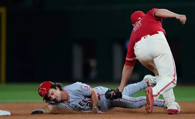 Los Angeles Angels' Adam Frazier, left, is tagged out attempting to steal second by Texas Rangers shortstop Corey Seager in the eighth inning of a baseball game Friday, Aug. 21, 2026, in Arlington, Texas. (AP Photo/Tony Gutierrez)