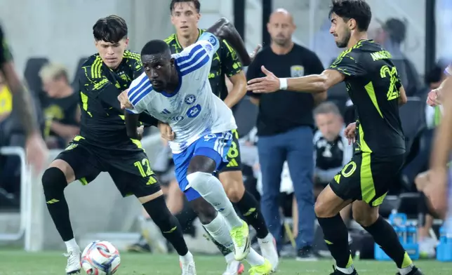 CF Montreal forward Prince Owusu, center, chases the ball between Columbus Crew defender Cesar Ruvalcaba, left, and midfielder Andre Gomes during the first half of an MLS soccer match in Columbus, Ohio, Wednesday, Aug. 19, 2026. (AP Photo/Paul Vernon)