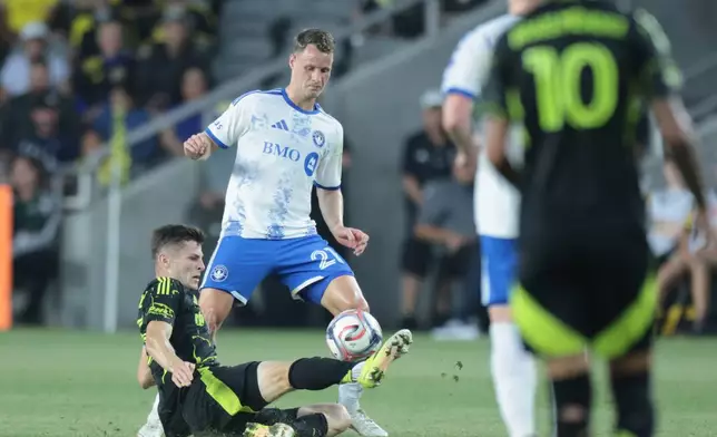 Columbus Crew Midfielder Sean Zawadzki, left, blocks a pass in front of CF Montreal midfield Fabian Herbers during the first of an MLS soccer match in Columbus, Ohio, Wednesday, Aug. 19, 2026. (AP Photo/Paul Vernon)