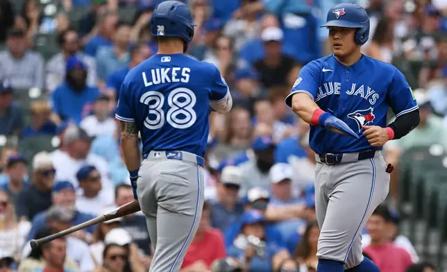 Toronto Blue Jays' Kazuma Okamoto, of Japan, right, celebrates with teammate Nathan Lukes (38) after scoring on a disengagement violation during the first inning of a baseball game against the Chicago Cubs in Chicago, Thursday, Aug. 6, 2026. (AP Photo/Paul Beaty)