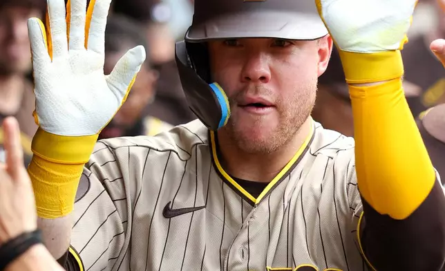 San Diego Padres' Gavin Sheets celebrates in the dugout after hitting a home run in the second inning of a baseball game against the Cleveland Guardians in Cleveland, Sunday Aug. 16, 2026. (AP Photo/Tim Phillis)