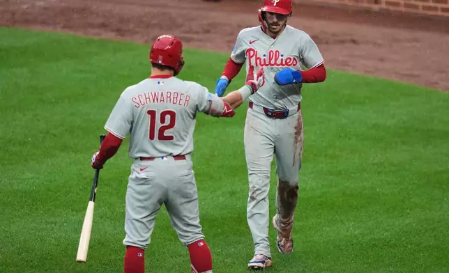 Philadelphia Phillies' Bryson Stott, right, celebrates with Kyle Schwarber (12) after scoring on a sacrifice flyout hit by Bryan de la Cruz during the sixth inning of a baseball game against the Baltimore Orioles, Sunday, Aug. 2, 2026, in Baltimore. (AP Photo/Stephanie Scarbrough)