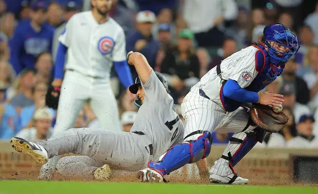 New York Yankees' Spencer Jones slides into home plate on New York Yankees' José Caballero's RBI single during the fifth inning of a baseball game against the Chicago Cubs, Saturday, Aug. 1, 2026, in Chicago. (AP Photo/Melissa Tamez)