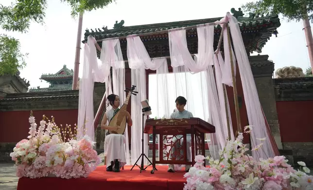 Chinese classical music performers perform at a festival to celebrate Qixi at the Beijing Folk Custom Museum in Beijing, Wednesday, Aug. 19, 2026. (AP Photo/Achmad Ibrahim)