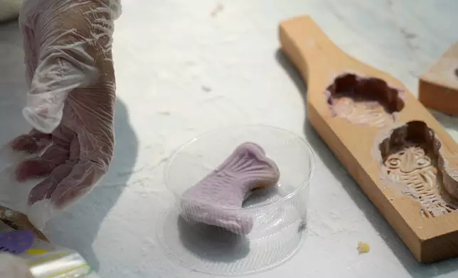 Participants create qiaoguo, a pastry made by pressing dough into decorative molds, during a festival to celebrate Qixi at the Beijing Folk Custom Museum in Beijing, Wednesday, Aug. 19, 2026. (AP Photo/Achmad Ibrahim)