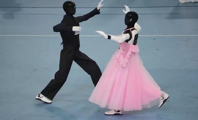 Humanoid robots compete in dance during the World Humanoid Robot Games in Beijing, Tuesday, Aug. 25, 2026. (AP Photo/Achmad Ibrahim)