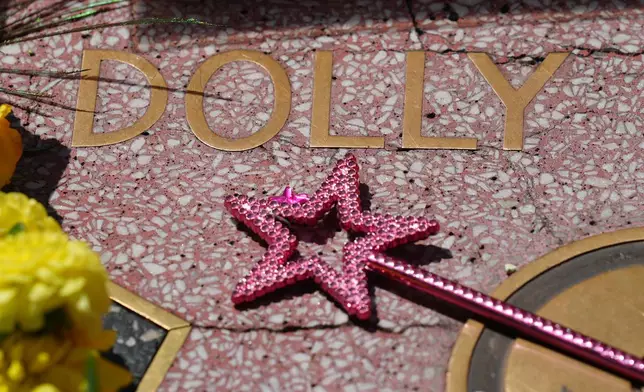 A wand with a star is placed over Dolly Parton's star on the Hollywood Walk of Fame Tuesday, Aug. 25, 2026, in Los Angeles. (AP Photo/Chris Pizzello)