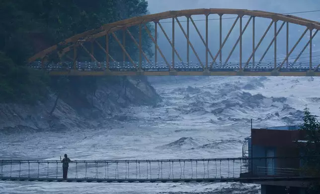 A resident looks at the swollen Trishuli river in Galchhi, Dhading District, Nepal, Sunday, Aug. 30, 2026. (AP Photo/Niranjan Shrestha)