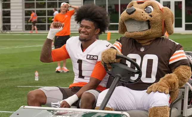 Cleveland Browns wide receiver KC Concepcion (1) arrives with mascot Chomps during an NFL football training camp, Saturday, Aug. 1, 2026, in Berea, Ohio. (AP Photo/Sue Ogrocki)