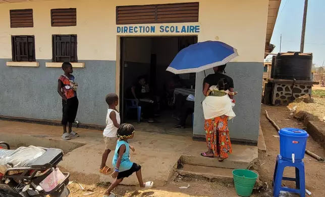 A parent who came for her child's school resumption stands outside the school in Ituri province, eastern Congo, Thursday, Aug. 27, 2026. (AP Photo/Constant Same Bagalwa)
