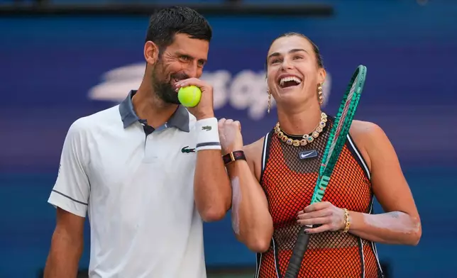 Novak Djokovic, of Serbia, left, and Aryna Sabalenka, of Belarus, share a laugh during a mixed doubles match at the U.S. Open tennis championships, Tuesday, Aug. 25, 2026, in New York. (AP Photo/Yuki Iwamura)