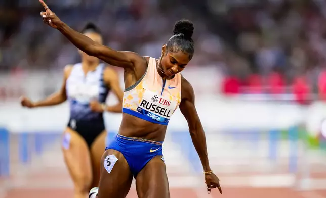 United States' Masai Russell celebrates winning the women's 100-meter hurdles race, setting a new world record, at the Diamond League athletics meeting, Thursday, Aug. 27, 2026, in Zurich, Switzerland. (Jean-Christophe Bott/Keystone via AP)