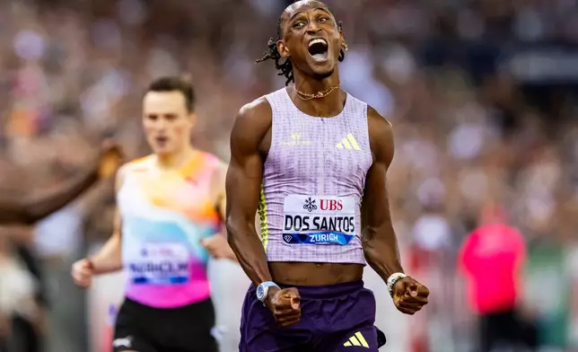 Brazil's Alison dos Santos celebrates winning the men's 400-meter hurdles, setting a new world record, at the Diamond League athletics meeting, Thursday, Aug. 27, 2026, in Zurich, Switzerland. (Jean-Christophe Bott/Keystone via AP)