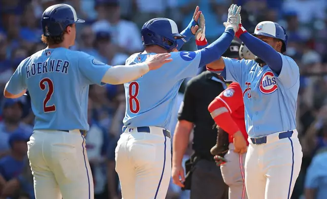 Chicago Cubs' Pedro Ramírez, left, celebrates with teammates Ian Happ, middle, and Nico Hoerner, left after hitting a three-run home run during the eighth inning of a baseball game against the Cincinnati Reds, Friday, Aug. 28, 2026, in Chicago. (AP Photo/Melissa Tamez)