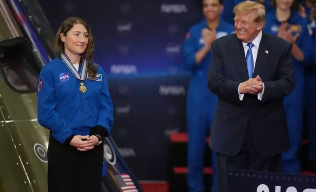 President Donald Trump applauds during a Congressional Space Medal of Honor ceremony at NASA's Johnson Space Center, Friday, Aug. 28, 2026, in Houston, after putting a medal on Artemis II Astronaut and Mission Specialist Christina Koch. (AP Photo/Karen Warren)