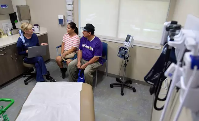 Doctor Kirsten Carter, attends a chronic care appointment for Ana Bautista, and Cesar Granda, of Orlando, Fla., during an appointment at Grace Medical Home in Orlando, Wednesday, Aug. 12, 2026. (AP Photo/Jacquelyn Martin)