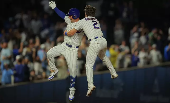 Chicago Cubs' Alex Bregman celebrates teammate Nico Hoerner after hitting the game winning hit to score Carson Kelly during the ninth inning of a baseball game against the Chicago White Sox, Tuesday, Aug. 18, 2026, in Chicago. (AP Photo/Melissa Tamez)