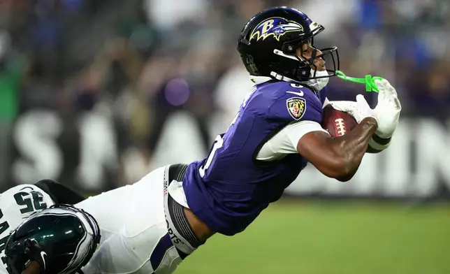 Baltimore Ravens wide receiver Ja'Kobi Lane, right, stretches to score a touchdown as he is defended by Philadelphia Eagles cornerback Michael Carter (35) during the first half of an NFL preseason football game Saturday, Aug. 15, 2026, in Baltimore. (AP Photo/Nick Wass)